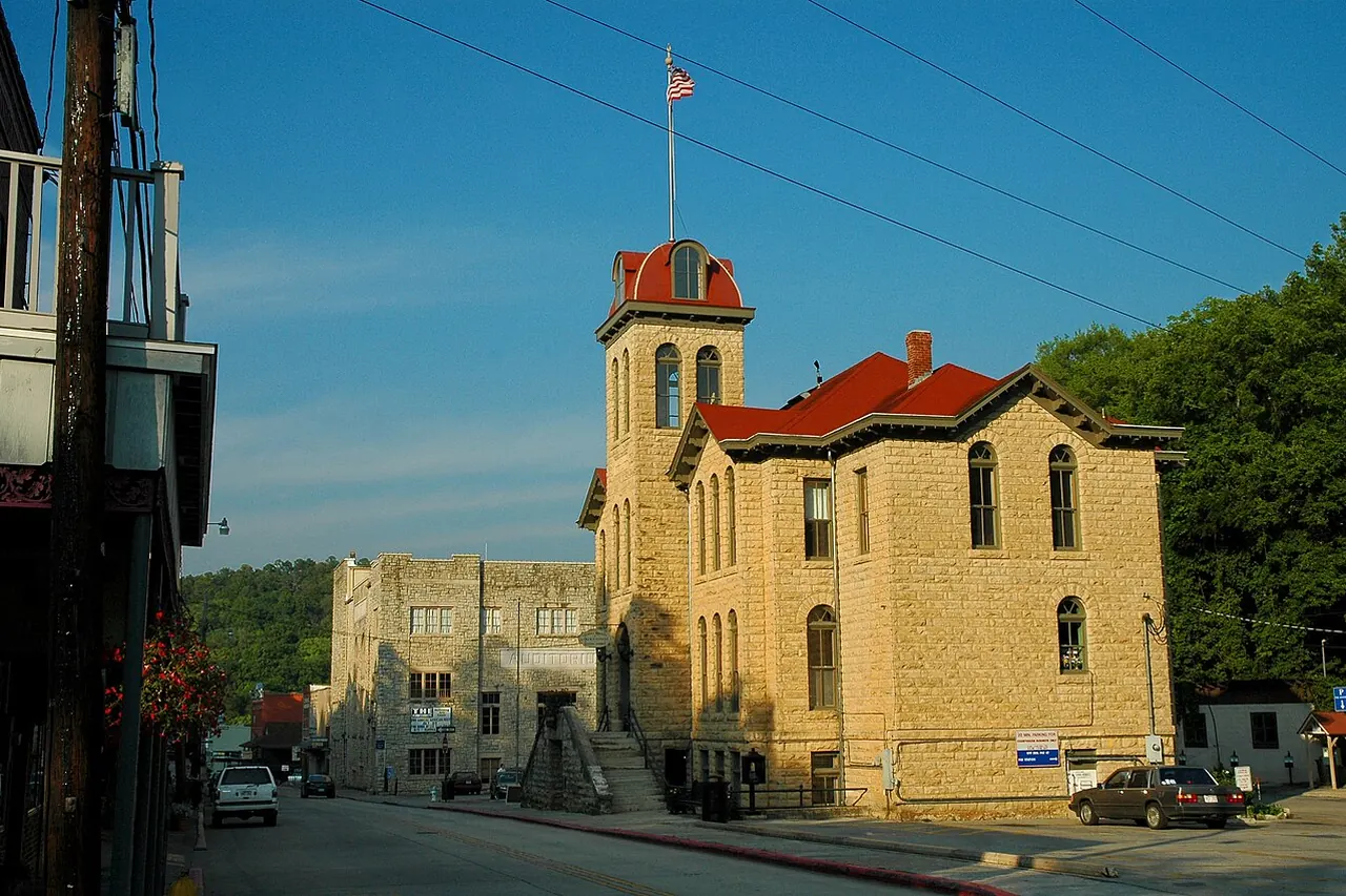 A two-storey stone courthouse with a clock tower