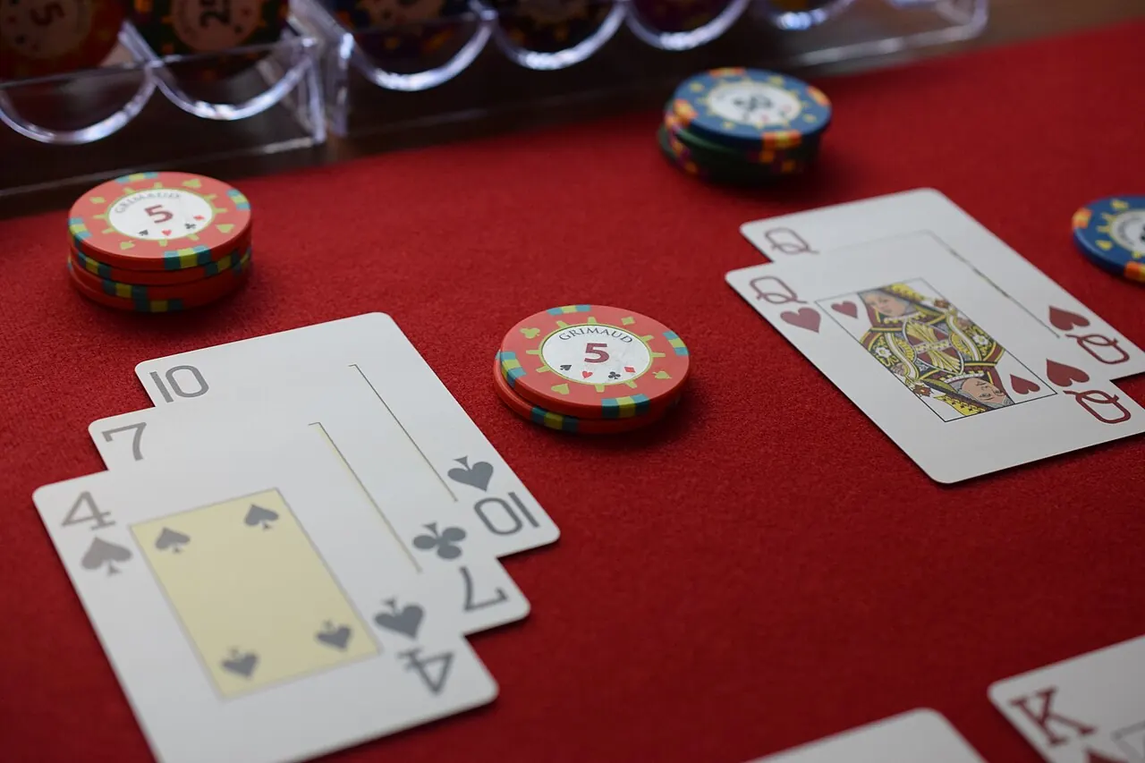Two blackjack hands and stacked chips on red felt
