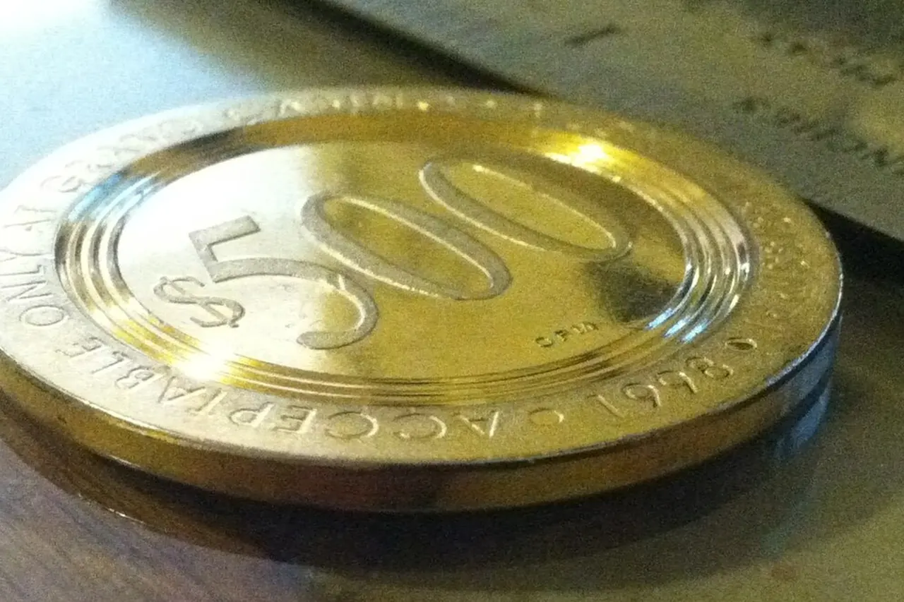 A single large-denomination casino chip lying on wood