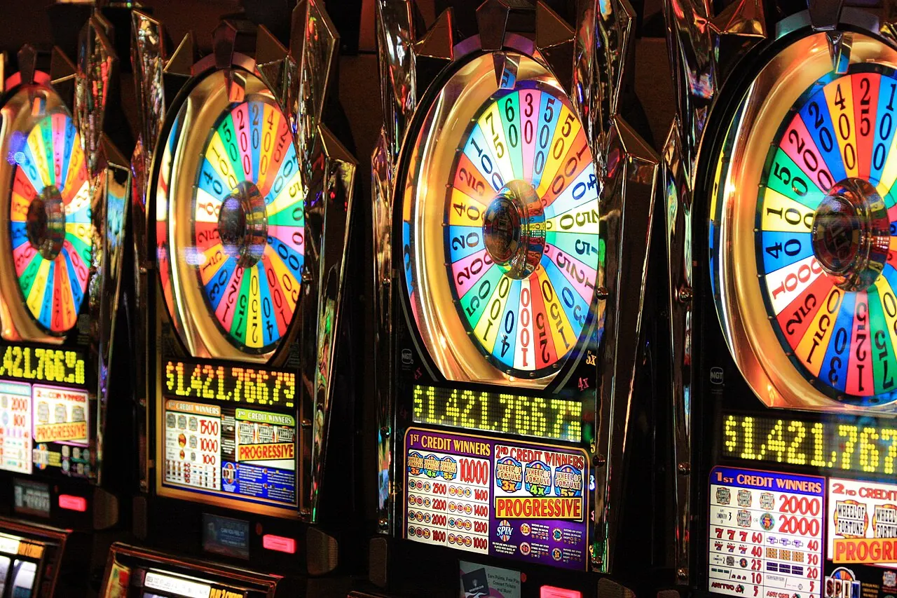 A row of wheel-topped slot machines on a casino floor