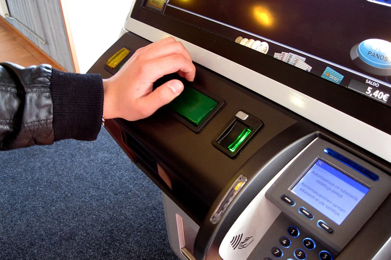 A hand pressing the lit button deck of a slot machine