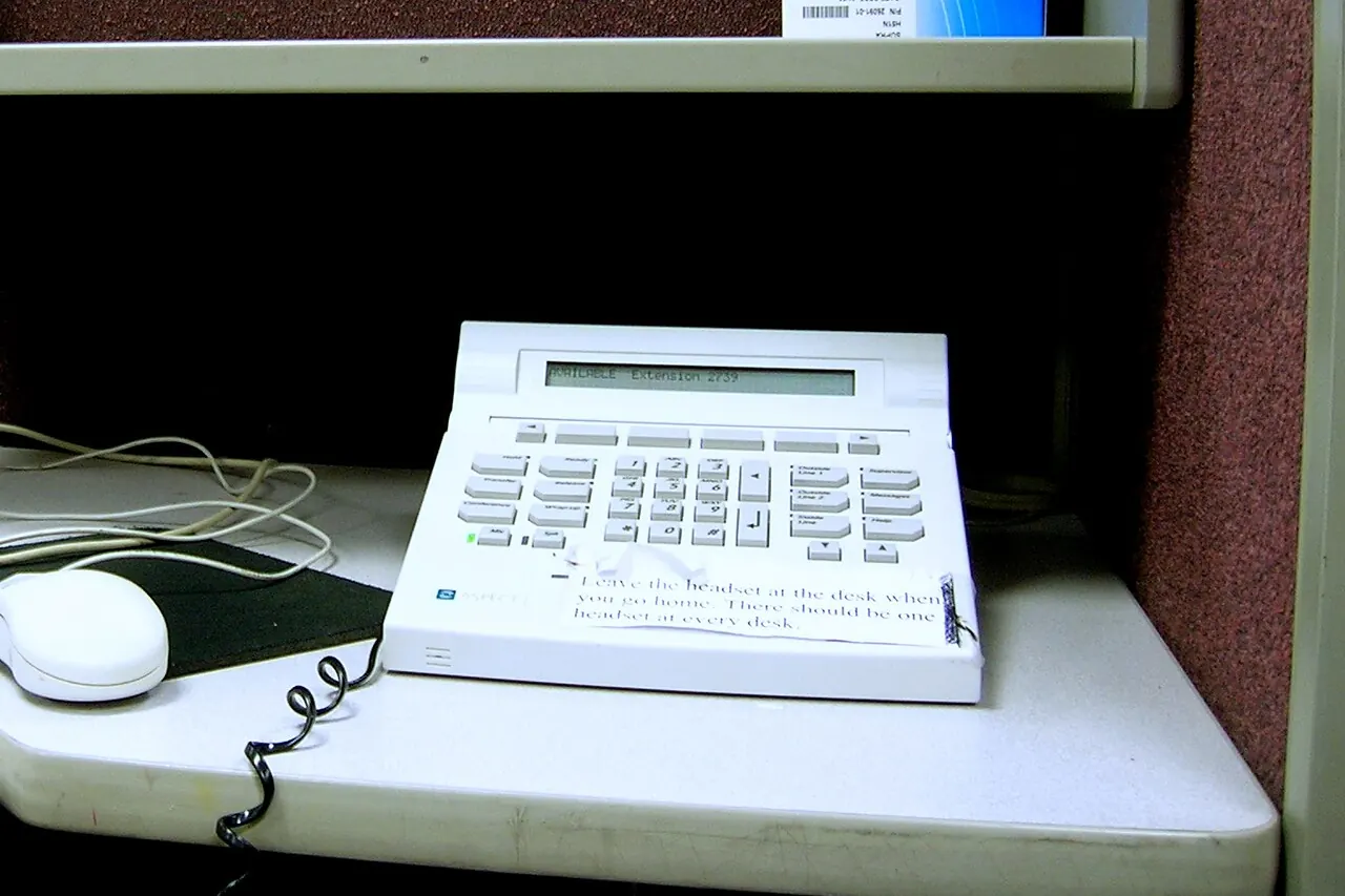 A handset-less desk telephone in a call centre cubicle